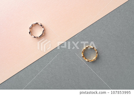 Two golden hoop earrings on paper background 107853995