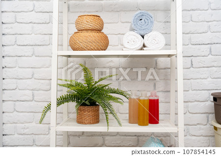 Rolled fluffy towels on shelf in bathroom Rolled fluffy towels on shelf in bathroom 107854145
