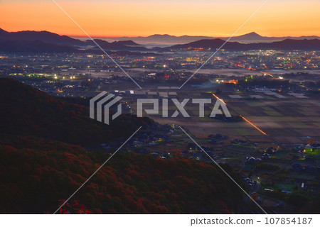 View of the foot of Mt. Okoyama, Mt. Mibo, and Mt. Tsukuba in the distance before dawn from the small peak on the south side of Mt. Okoyama in late autumn. 107854187