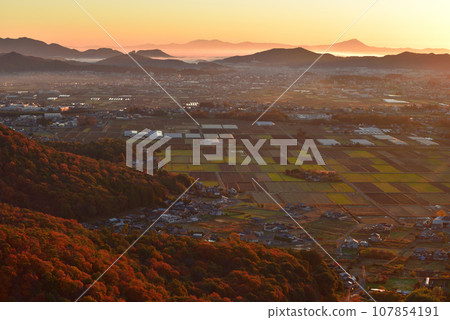 View of the foot of Mt. Okoyama, Mt. Mibo, and the distant direction of Mt. Tsukuba at dawn from the small peak on the south side of Mt. Okoyama in late autumn. 107854191