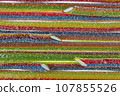 Texture of the marmalade strips, lined with rows of bright red-green-blue flowers, is sprinkled with sugar. 107855526