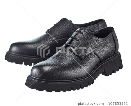 Amazing pair of men's derby boots made of pimpled dense black leather with lacing, on a high powerful sole, isolated on a white background. Amazing pair of men's derby boots made of pimpled dense black leather with lacing, on a high powerful sole, isolated on a white background. 107855531