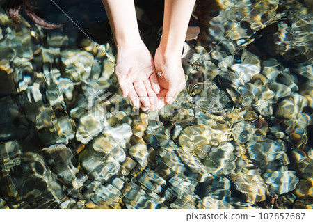 從山澗裡舀水的年輕女子 107857687