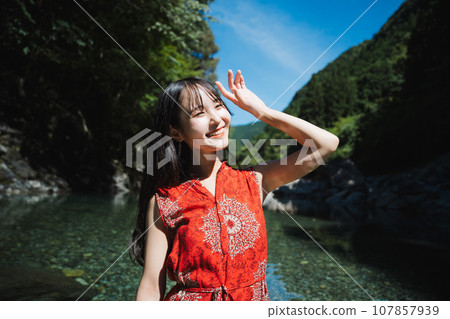 一個穿著紅色衣服的女人站在山澗裡 一個穿著紅色衣服的女人站在山澗裡 107857939