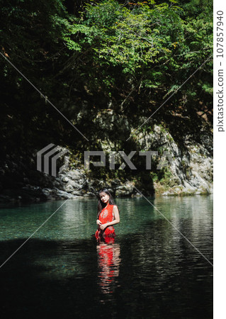 一個穿著紅色衣服的女人站在山澗裡 107857940