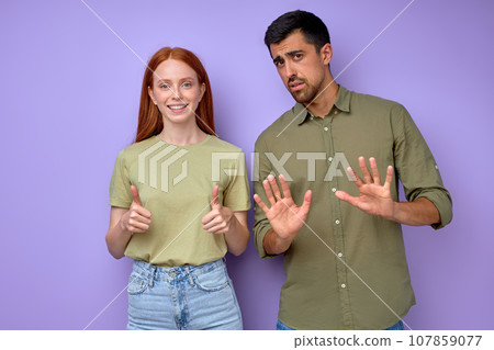 happy attractive red-haired girl saying ok, bearded man saying that he is bad happy attractive red-haired girl saying ok, bearded man saying that he is bad 107859077