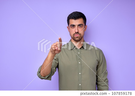 Hey, It's You. young serious man in casual clothes pointing index finger Hey, It's You. young serious man in casual clothes pointing index finger 107859178