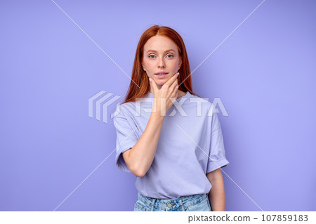 beautiful ginger girl with hand on her chin looking at camera beautiful ginger girl with hand on her chin looking at camera 107859183