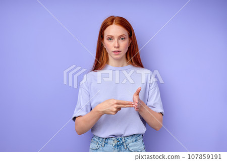 red-haired woman showing deaf mute BSL alphabet letter V. 107859191