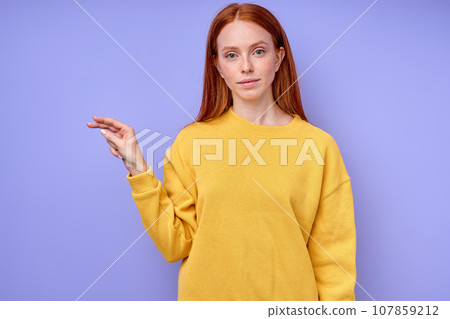 beautiful redhead serious girl, teacher showing letter P on blue background 107859212