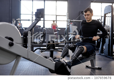 strong man concentrated on pilling rowing machine 107859678