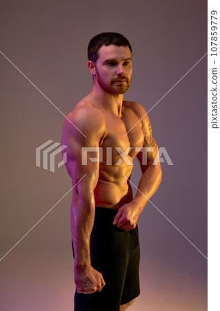 young sportsman with strong muscular arms demonstrates his body young sportsman with strong muscular arms demonstrates his body 107859779