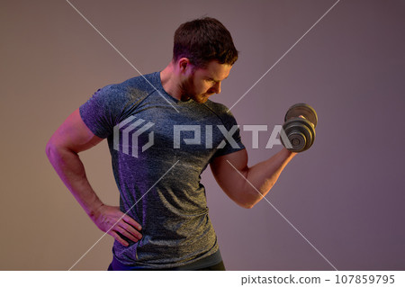 sportsman with perfect body exercising with dumbbell against brown background sportsman with perfect body exercising with dumbbell against brown background 107859795