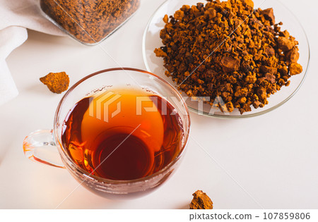 Healing tea from wild birch chaga mushroom in a cup on the table 107859806