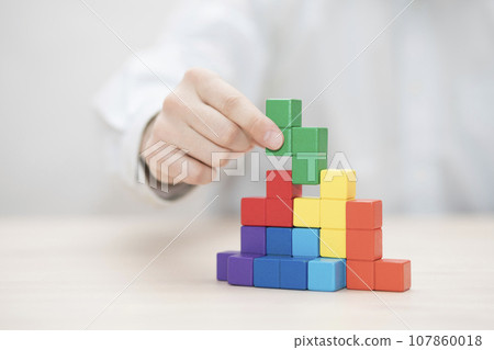 Man's hand stacking colorful wooden blocks. Business development concept 107860018