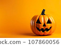 Halloween orange pumpkin decoration on a warm yellow background 107860056