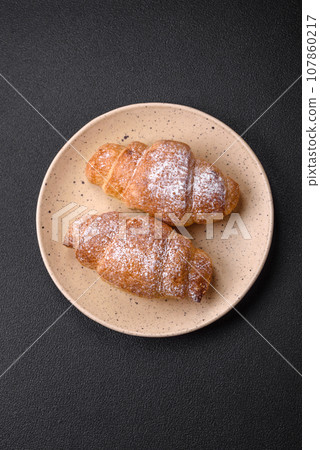 Delicious fresh sweet crispy croissants with chocolate cream on a ceramic plate 107860217
