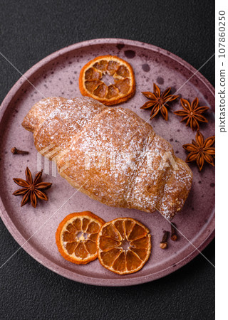 Delicious fresh sweet crispy croissants with chocolate cream on a ceramic plate Delicious fresh sweet crispy croissants with chocolate cream on a ceramic plate 107860250