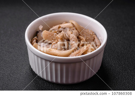 Delicious spicy mushrooms sliced and cooked in Korean style on a ceramic plate Delicious spicy mushrooms sliced and cooked in Korean style on a ceramic plate 107860308