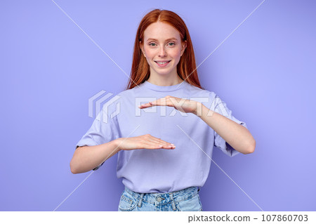 Young happy ginger girl wearing casual blue t shirt gesturing with hands Young happy ginger girl wearing casual blue t shirt gesturing with hands 107860703