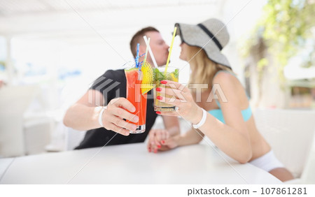 Woman and man kissing and having cooling cocktails, couple resting on luxury resort, chill 107861281