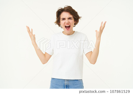 Portrait of angry woman, shaking hands and complaining, furious from frustration and disappointment, standing over white background Portrait of angry woman, shaking hands and complaining, furious from frustration and disappointment, standing over white background 107861529