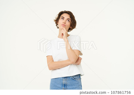 Portrait of thinking girl, smiling and pondering, making decision, contemplating something, standing over white background 107861756