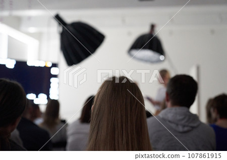 Unrecognizable people are sitting with their backs in the hall. I'm sitting at a lecture or a meeting at the university. business and entrepreneurship or the concept of learning. High quality photo Unrecognizable people are sitting with their backs in the hall. I'm sitting at a lecture or a meeting at the university. business and entrepreneurship or the concept of learning. High quality photo 107861915