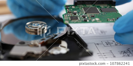 Male technician hold computer details, try to fix or collect device, dvd disc 107862241