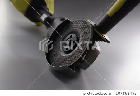 Grinder instrument for metal works, electrical saw on grey background 107862452