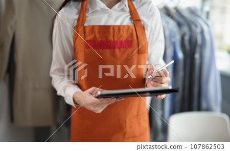 Dry cleaning company worker in uniform take order, high quality service 107862503