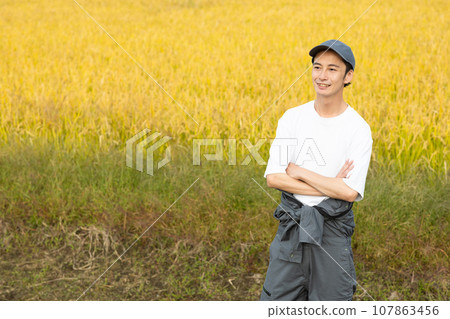 A refreshing man standing in a rice field 107863456