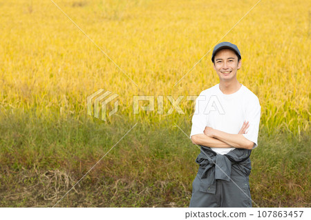 A refreshing man standing in a rice field 107863457