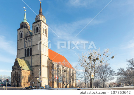 Scenic view of old St John Church in Magdeburg old city center against blue sky on cold frosty winter day. Snowy sunny german cityscape with ancient cathedral. European travel destination Scenic view of old St John Church in Magdeburg old city center against blue sky on cold frosty winter day. Snowy sunny german cityscape with ancient cathedral. European travel destination 107863642