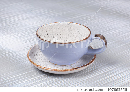 Empty ceramic cup and saucer on a gray background. Empty ceramic cup and saucer on a gray background. 107863856