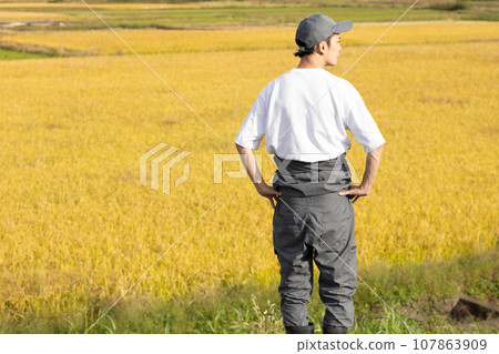 A refreshing man standing in a rice field 107863909