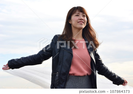 一個女人拿著一塊佈在風中搖曳 一個女人拿著一塊佈在風中搖曳 107864373