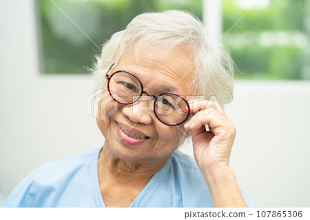 Asian senior woman wearing eyeglasses or vision glasses at home care service. Asian senior woman wearing eyeglasses or vision glasses at home care service. 107865306