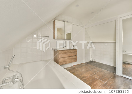 a bathroom with white walls and wood flooring in an attic - style space that has been used for storage 107865555