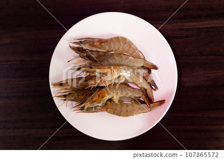 Raw shrimps on white plate. Raw shrimps on white plate. 107865572