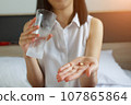 Close up of the Woman takes medicines with glass. 107865864