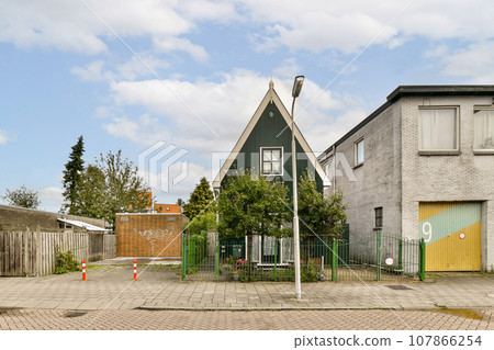 an empty street with houses in the background and a stop sign on the side of the road that says no parking 107866254