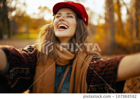 happy trendy 40 years old woman in red hat taking selfie happy trendy 40 years old woman in red hat taking selfie 107868582