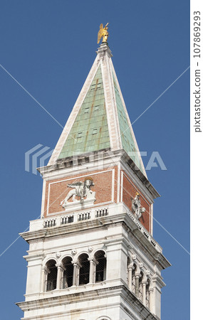 Piazza San Marco with top of Campanile di San Marco with golden angel on top at City of Venice on sunny summer day. 107869293