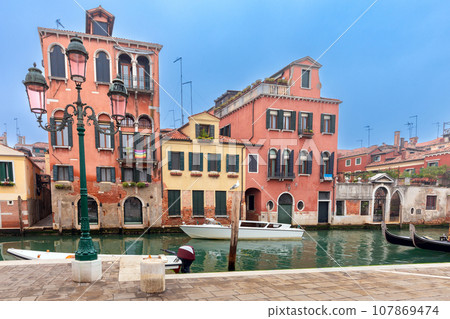 Traditional colorful Venetian houses along the canal at sunset. Traditional colorful Venetian houses along the canal at sunset. 107869474