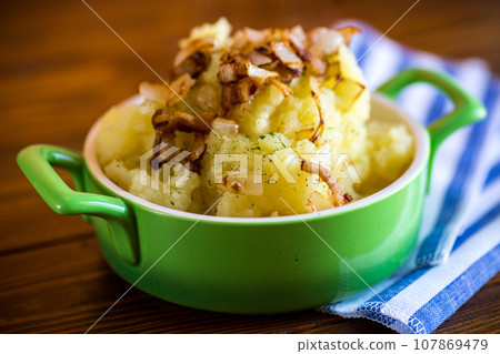 Cooked mashed potatoes with fried chopped bacon and onions. 107869479