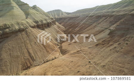 Colorful high mountains and a canyon made of clay Colorful high mountains and a canyon made of clay 107869581