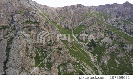 Drone view of a green gorge with high rocky cliffs Drone view of a green gorge with high rocky cliffs 107869621