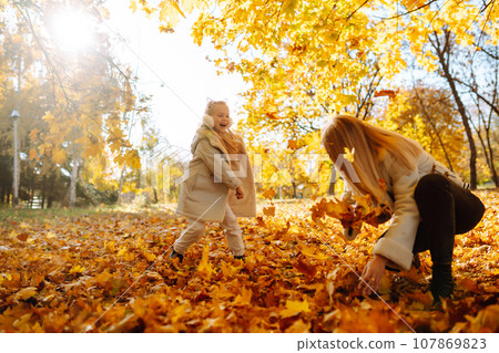 Portrait of happy mother and daughter in autumn forest at sunset. Autumn women. Portrait of happy mother and daughter in autumn forest at sunset. Autumn women. 107869823