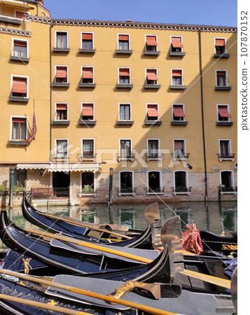 Canal with gondolas in Venice, Italy. Architecture and landmarks of Venice. Postcard with gondola. 107870152
